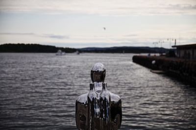 Rear view of man in boat on river against sky