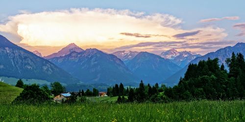 Scenic view of field and mountains against sky