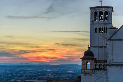 Basilica of san francisco amidst town against cloudy sky during sunset