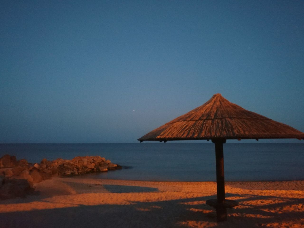 sky, tranquil scene, clear sky, scenics - nature, tranquility, sea, copy space, water, horizon, beauty in nature, horizon over water, thatched roof, land, blue, nature, roof, no people, beach, idyllic, outdoors