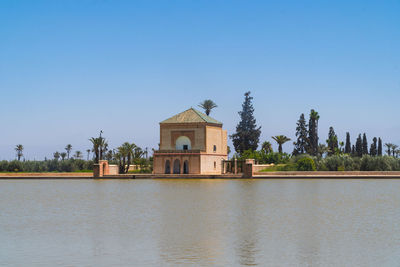 Building by lake against sky