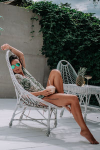 Woman sitting on chair at swimming pool