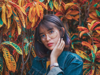 Portrait of young woman with autumn leaves