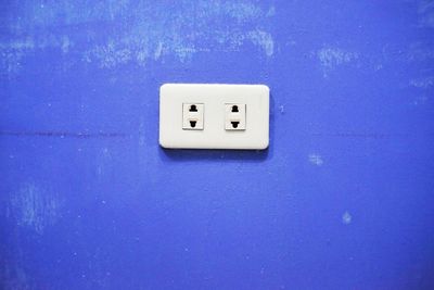 Close-up of electric light on blue wall