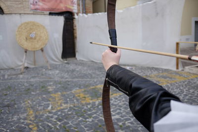 Cropped hand of archer aiming at target