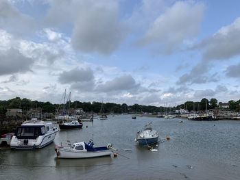 Sailboats moored in sea against sky