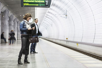 Business people waiting for train at railroad station