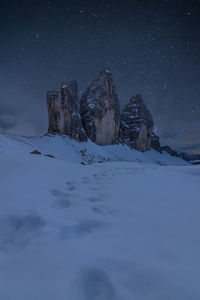 Scenic view of snowcapped field against sky at night