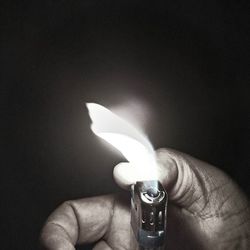 Cropped image of hand holding over black background