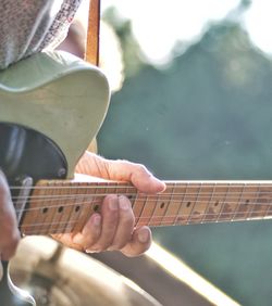 Midsection of man playing guitar