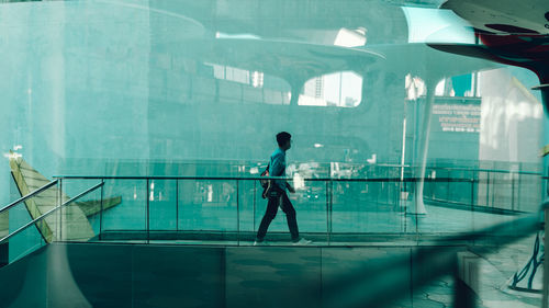 Full length of man standing on glass window