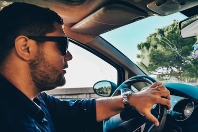 Side view of young man in car