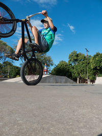 Man riding bicycle against sky