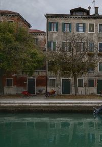 Canal by buildings in city