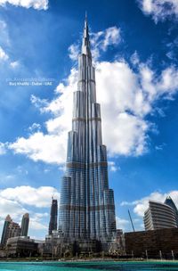 Low angle view of skyscrapers against cloudy sky