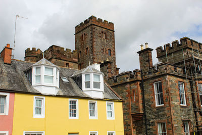 Low angle view of buildings in town against sky