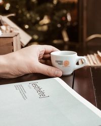 Hand holding coffee cup on table