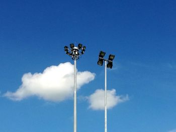 Low angle view of floodlights against blue sky