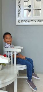Portrait of boy sitting on table at home