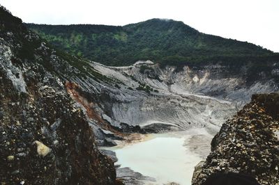 Scenic view of river amidst mountains against sky