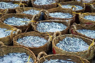 Full frame shot of fishes in wicker baskets at market for sale