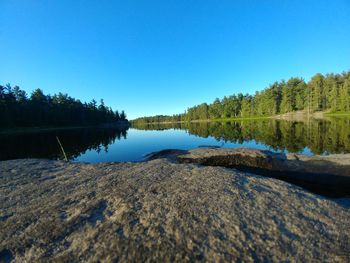 Scenic view of lake against clear blue sky