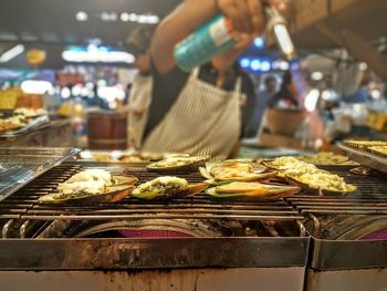 Close-up of man preparing food at market stall