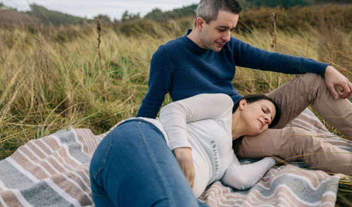 Pregnant couple relaxing on grass