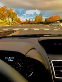 Cars on road against sky seen through car windshield