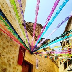 Low angle view of multi colored umbrellas against sky