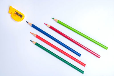 High angle view of colored pencils against white background