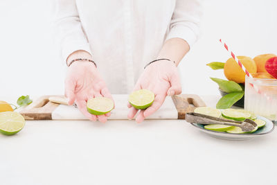 Midsection of woman with vegetables on table