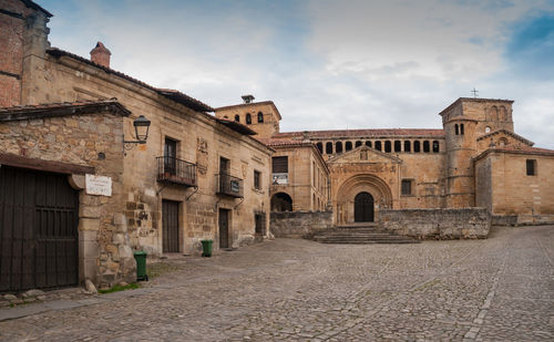 Street amidst old buildings in city against sky