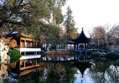 Built structure by river against sky