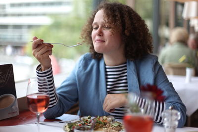 Side view of woman eating food at restaurant