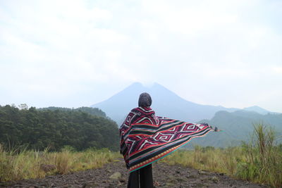 Rear view of woman with scarf standing on land