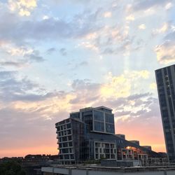 Buildings against cloudy sky at sunset