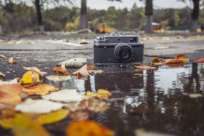 Close-up of camera by puddle on road