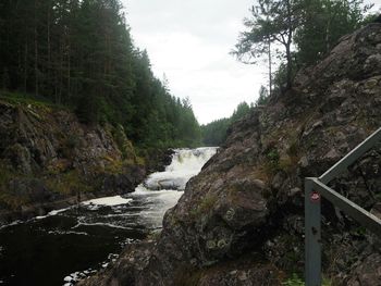 Scenic view of waterfall against sky