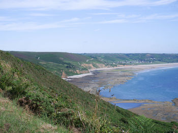 Scenic view of landscape by sea against sky