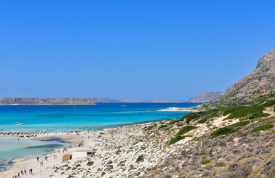 Scenic view of beach against clear blue sky