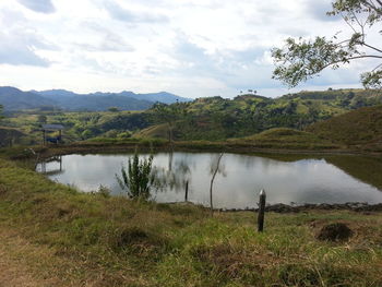 Scenic view of lake against cloudy sky