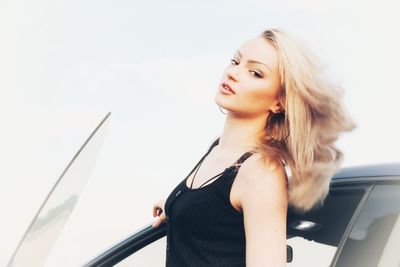 Portrait of young woman looking away against white background