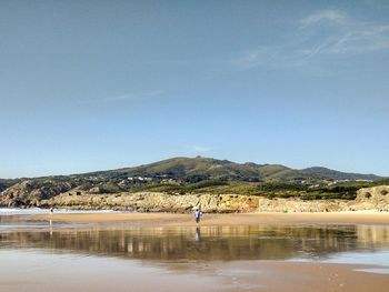 Man standing on beach against clear sky