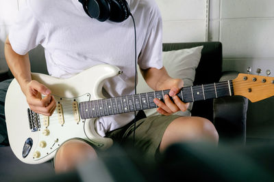 Midsection of man playing guitar