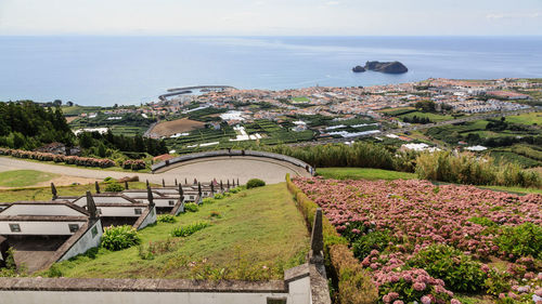 High angle view of buildings by sea against sky