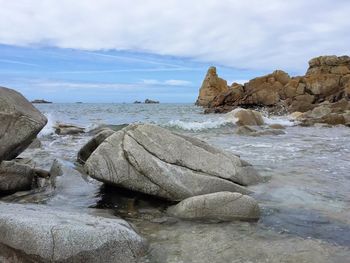 Rocks on beach against sky