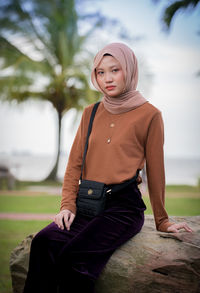 Portrait of young woman sitting outdoors