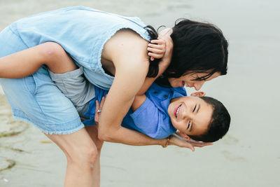 Laughter as mother dips young son while at the beach