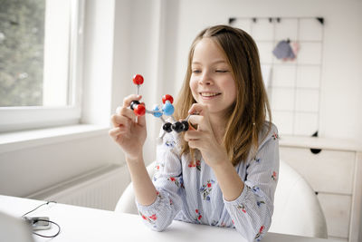 Portrait of smiling girl holding table